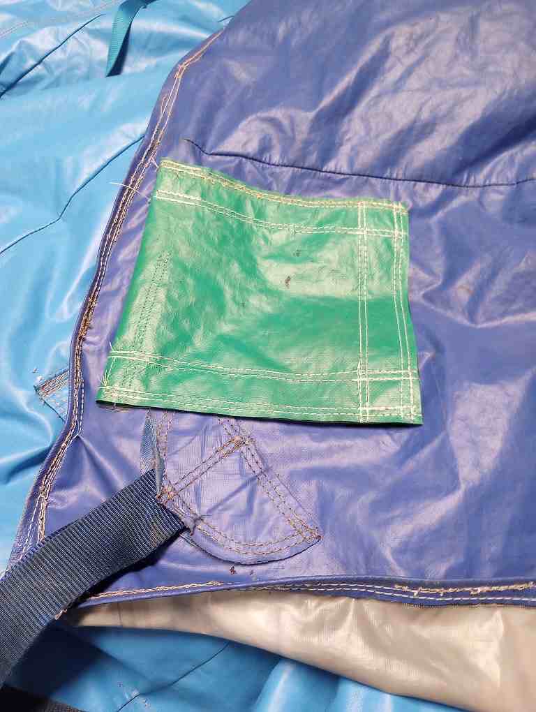 Heavy-use seam reinforced with a stitched vinyl panel